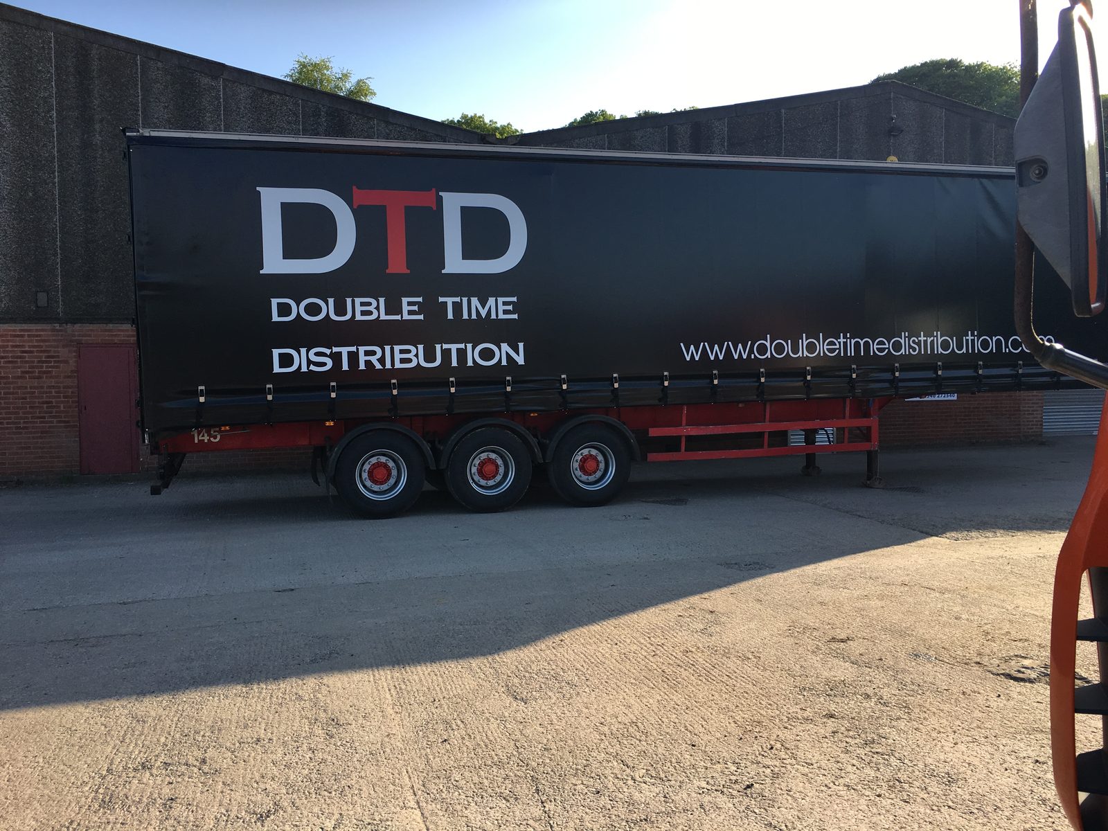 Double Time Distribution curtainsider trailer at the depot in the evening